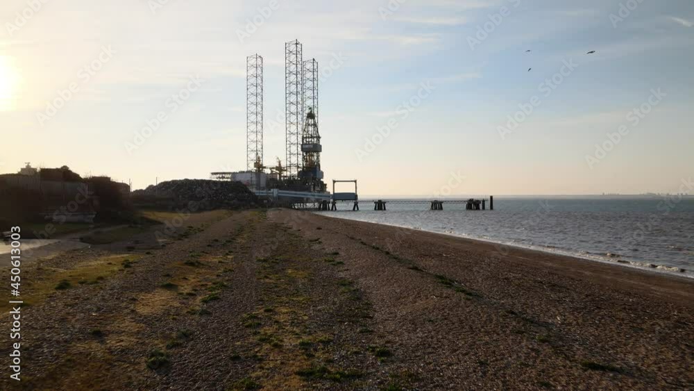 Cinematic low-level aerial over the beach at Sheerness Kent towards a North Sea Oil Rig undergoing maintenance Cinematic low-level aerial over the beach at Sheerness Kent towards a North Sea Oil Rig undergoing maintenance