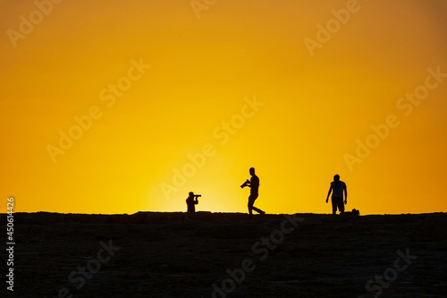 Silhouettes of photographers against the background of the rising sun. Makhtesh Ramon
