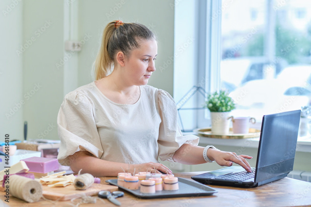 Small business owner. Portrait of mature woman standing at her shop behind the laptop and smiling. female online store seller entrepreneur packing package post shipping box preparing delivery parcel. Small business owner. Portrait of mature woman standing at her shop behind the laptop and smiling. female online store seller entrepreneur packing package post shipping box preparing delivery parcel.