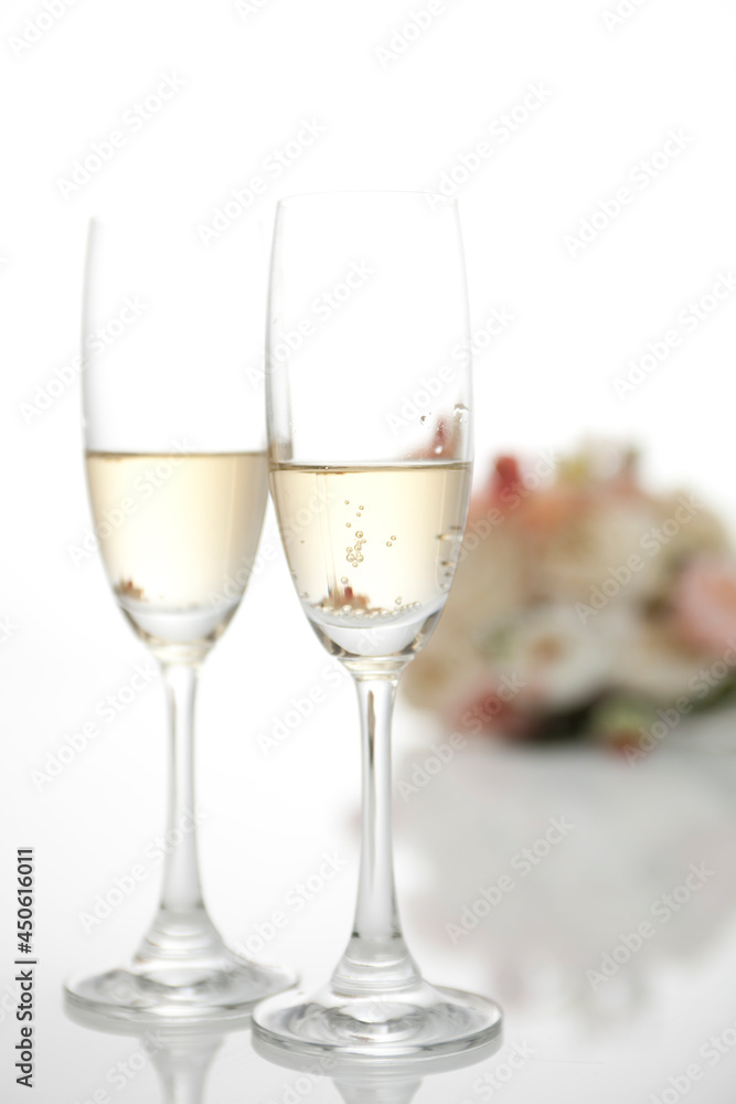 Two champagne glasses with a wedding bouquet