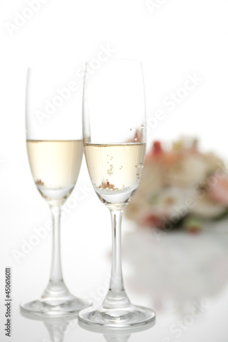 Two champagne glasses with a wedding bouquet