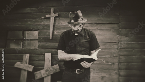 Tableau sur toile Clergyman, reverend or priest wearing a clerical collar and reading a bible