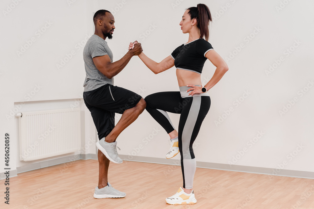 Fototapeta premium Happy multinational couple stretching together during fitness training