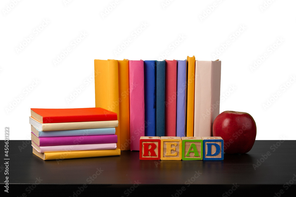 Naklejka premium Stack of books and apple on tabletop against white background