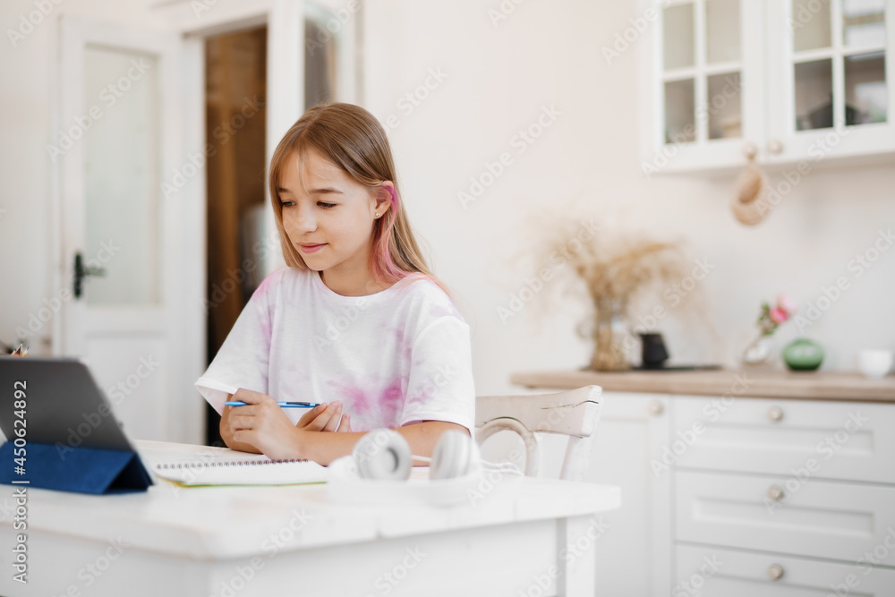 Homeschooled little young girl student having online class using digital tablet Homeschooled little young girl student having online class using digital tablet