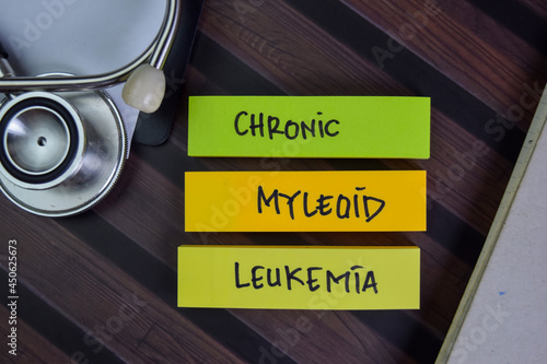 Chronic Myleoid Leukemia write on sticky notes isolated on Wooden Table. photo