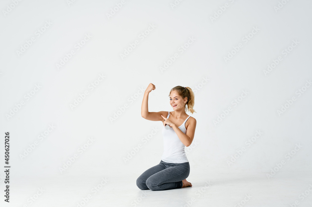 woman with dumbbells in her hands sitting on the floor exercise gym woman with dumbbells in her hands sitting on the floor exercise gym