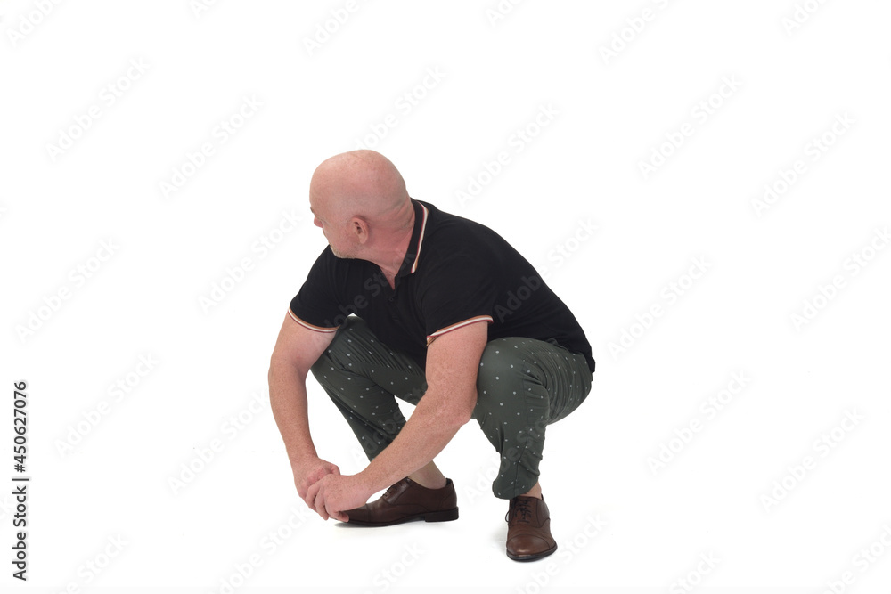 man looking away and sitting squatting on white background man looking away and sitting squatting on white background