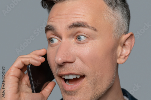 Close up of surprised man talking on smartphone