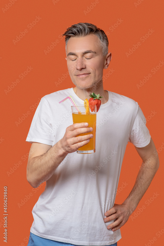 Man with closed eyes with glass of fruit cocktail Man with closed eyes with glass of fruit cocktail