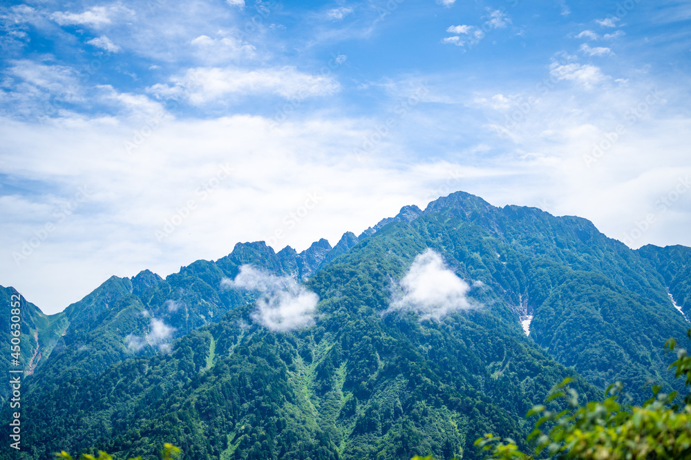 Obraz premium 富山県中新川郡上市町の中山から立山の剱岳を望む登山をしている風景 A view of mountain climbing with a view of Tsurugidake in Tateyama from Nakayama in Kamiichi Town, Nakashinagawa County, Toyama Prefecture.