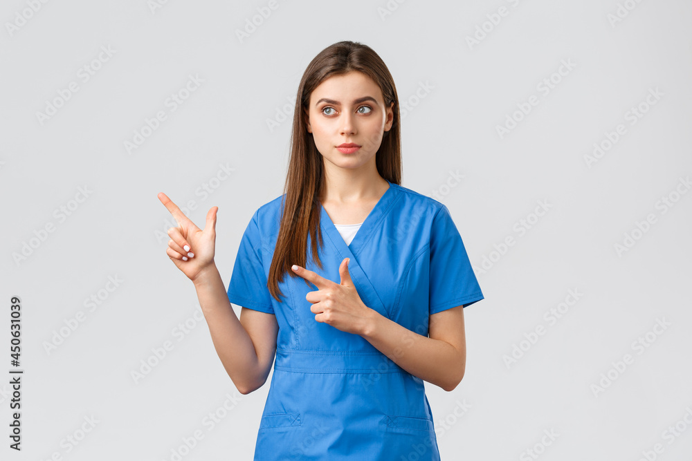 Healthcare workers, prevent virus, insurance and medicine concept. Dreamy  cute nurse or doctor in blue scrubs, looking and pointing upper left  corner, reading banner info, grey background Photos | Adobe Stock
