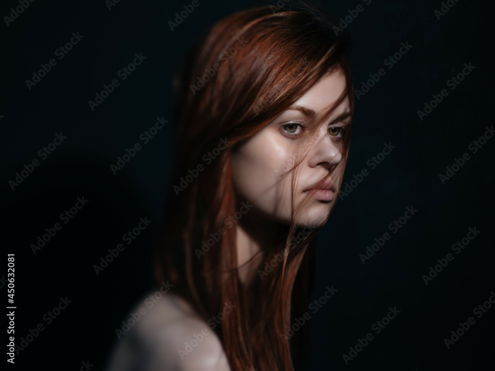 pretty red-haired woman naked shoulders posing close-up dark background pretty red-haired woman naked shoulders posing close-up dark background