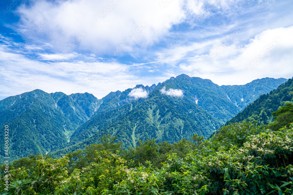 Obraz premium 富山県中新川郡上市町の中山から立山の剱岳を望む登山をしている風景 A view of mountain climbing with a view of Tsurugidake in Tateyama from Nakayama in Kamiichi Town, Nakashinagawa County, Toyama Prefecture.