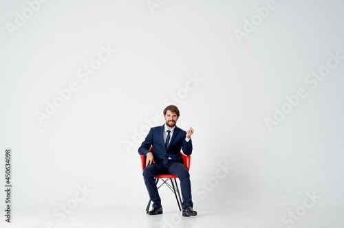 business man in suit sitting on red chair emotions office fun