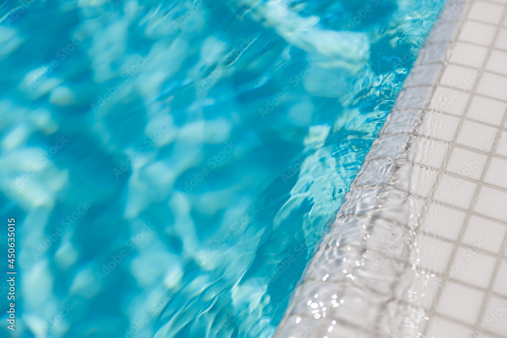Surface of blue swimming pool. Summer water sport, recreational background. Texture of water surface, blue turquoise vivid bright sunny closeup. Relax, calmness pool edge