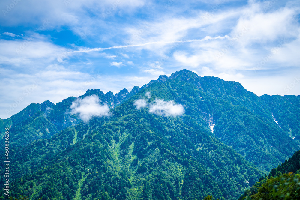 Obraz premium 富山県中新川郡上市町の中山から立山の剱岳を望む登山をしている風景 A view of mountain climbing with a view of Tsurugidake in Tateyama from Nakayama in Kamiichi Town, Nakashinagawa County, Toyama Prefecture.