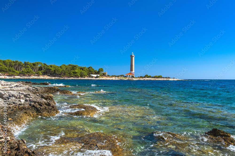 Lighthouse of Veli Rat on the island of Dugi Otok, Croatia, beautiful seascape and rocks in foreground