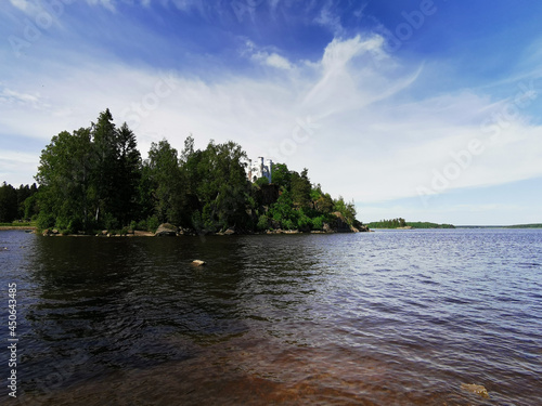 View from the shore of the Ludwigsburg Chapel on Ludwigstein Island in the Monrepos Rock Nature Park of Vyborg against a beautiful blue sky with clouds.