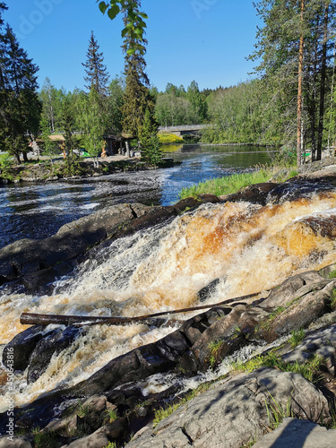 Side view of the Ahvenkoski waterfall on the Tokhmayoki River in Karelia on a clear summer morning.. photo