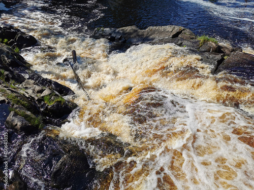 View of the Akhvenkoski waterfall on the Tokhmayoki River in Karelia from the pedestrian bridge passing over it. photo