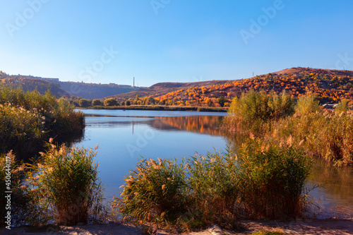 Lake surrounded by hills . Fishing in the autumn morning