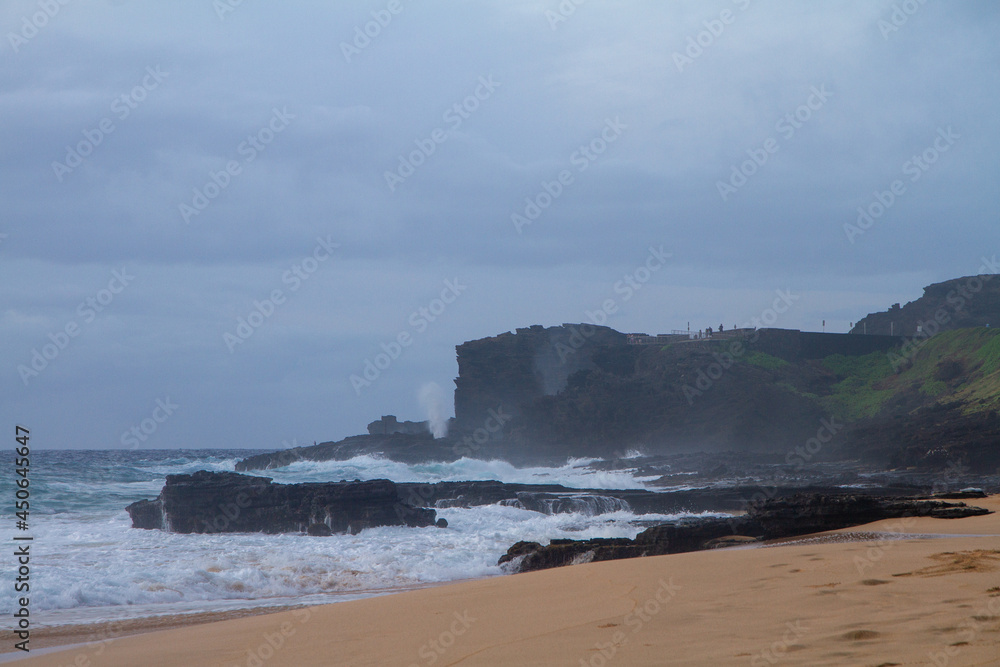 Hawaiian natural water blowhole in action on a cloudy sunrise