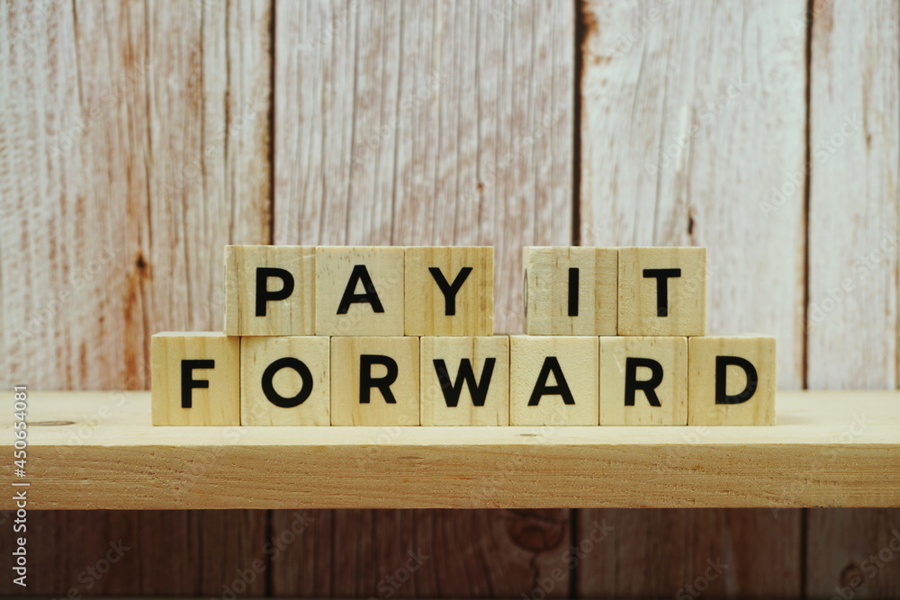 Pay It Forward alphabet letter on shelves wooden background Pay It Forward alphabet letter on shelves wooden background