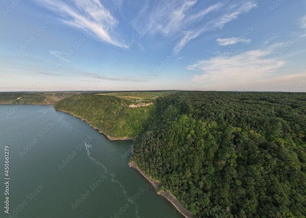 Aerial top view of the river with green water and coniferous coast