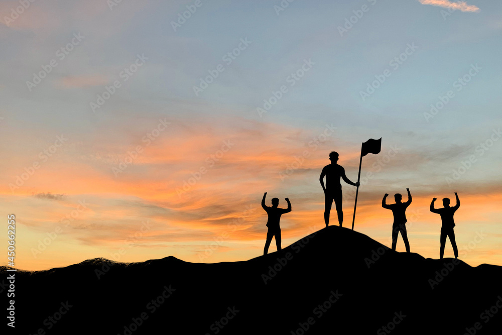 Silhouette of business leader holding a flag and employee making high hands over head on top of the mountain in beautiful sunset sky evening time for business success and teamwork concept in company.