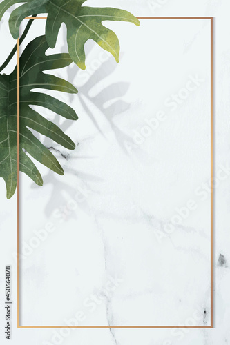 Gold frame with philodendron radiatum leaf pattern on white marble background vector photo