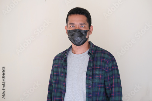 Adult Asian man wearing black medical mask photo