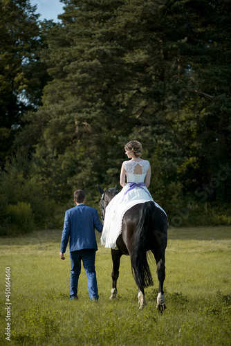 Happy woman bride is ridding the horse