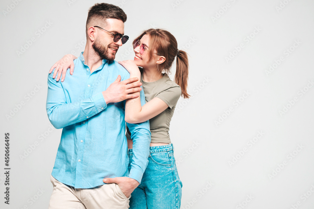 Smiling beautiful woman and her handsome boyfriend. Happy cheerful family having tender moments on grey background in studio.Pure cheerful models hugging.Embracing each other in sunglasses Smiling beautiful woman and her handsome boyfriend. Happy cheerful family having tender moments on grey background in studio.Pure cheerful models hugging.Embracing each other in sunglasses