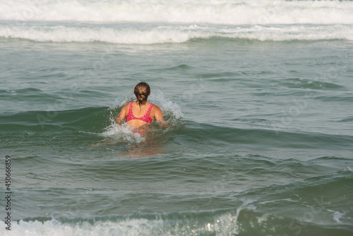 beautiful young woman having fun in the waves