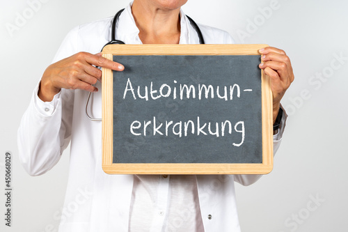 Ärztin hält eine Tafel auf der Autoimmunerkrankung steht photo