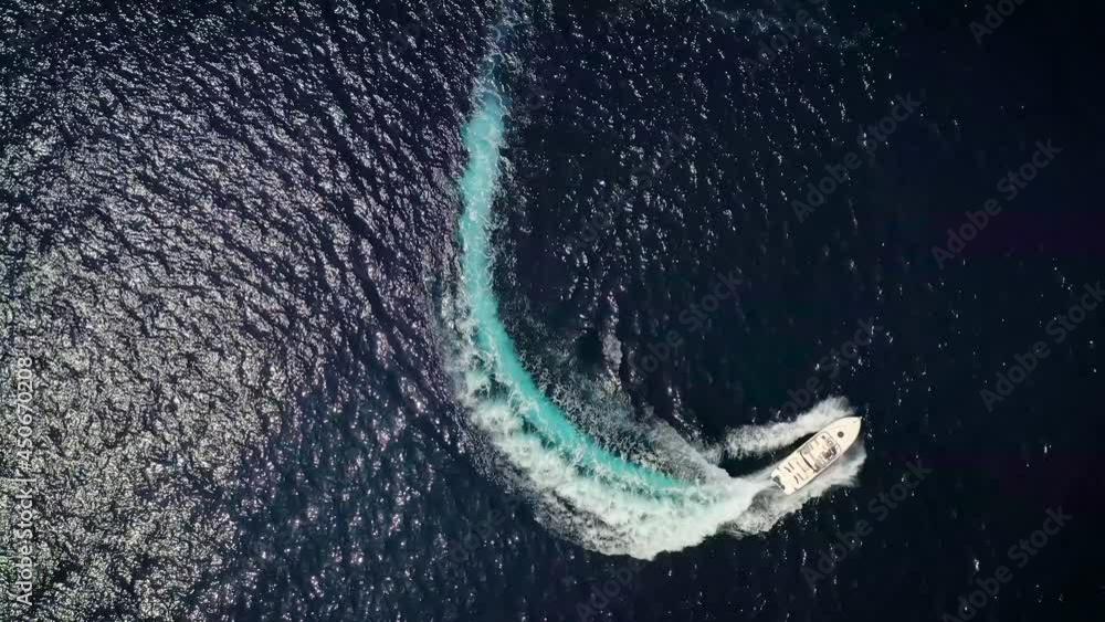 Luxury motor boat forms a circle of waves and bubbles with its engines ...