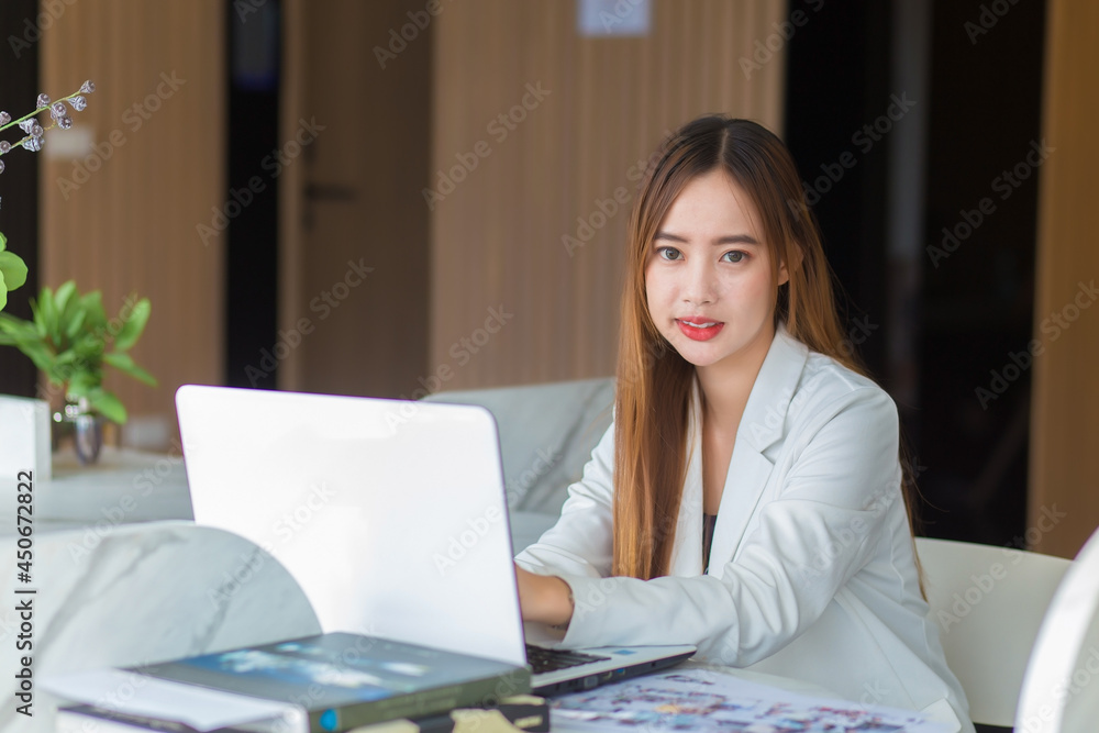Asian business woman working in co-working space with laptop paper work (Business woman concept.) Asian business woman working in co-working space with laptop paper work (Business woman concept.)