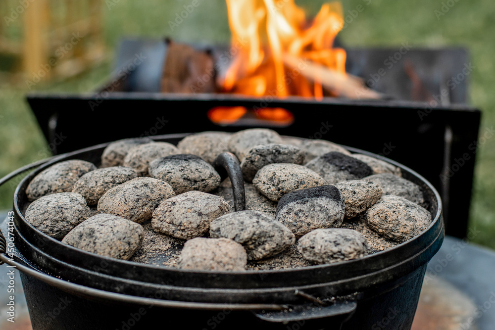 Dutch oven camp cooking with coal briquettes beads on top. Campfire Dutch oven camp cooking with coal briquettes beads on top. Campfire