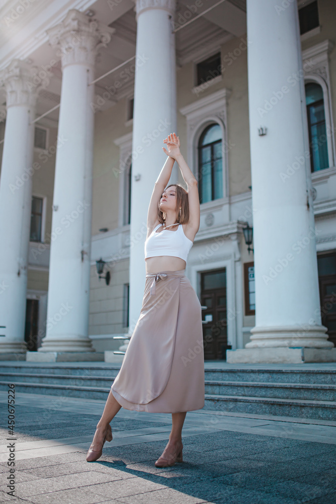 a beautiful young girl is walking around the city, spinning, dancing on the street a beautiful young girl is walking around the city, spinning, dancing on the street