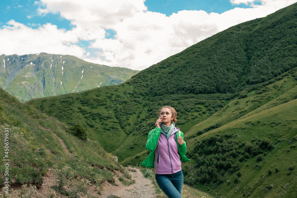 Freedom traveler woman standing with phone in hands and enjoy a wonderful nature.