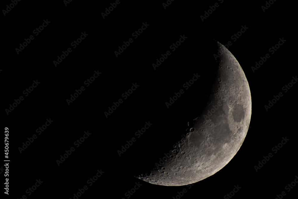 Half a moon in the black night sky. Craters and lunar seas Half a moon in the black night sky. Craters and lunar seas