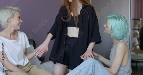 lesbian ladies in domestic casual clothes are going to spend time with redhead female, time to have sex together, smiling, want to get pleasure, sensual and tender. copy space. lgbt, homosexual photo