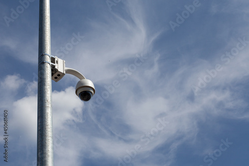 Singiel CCTV, white security camera against blue sky background. photo