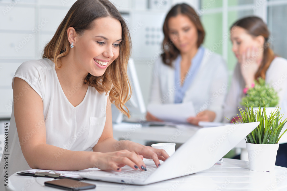 young women sit at the table and work in a modern office young women sit at the table and work in a modern office