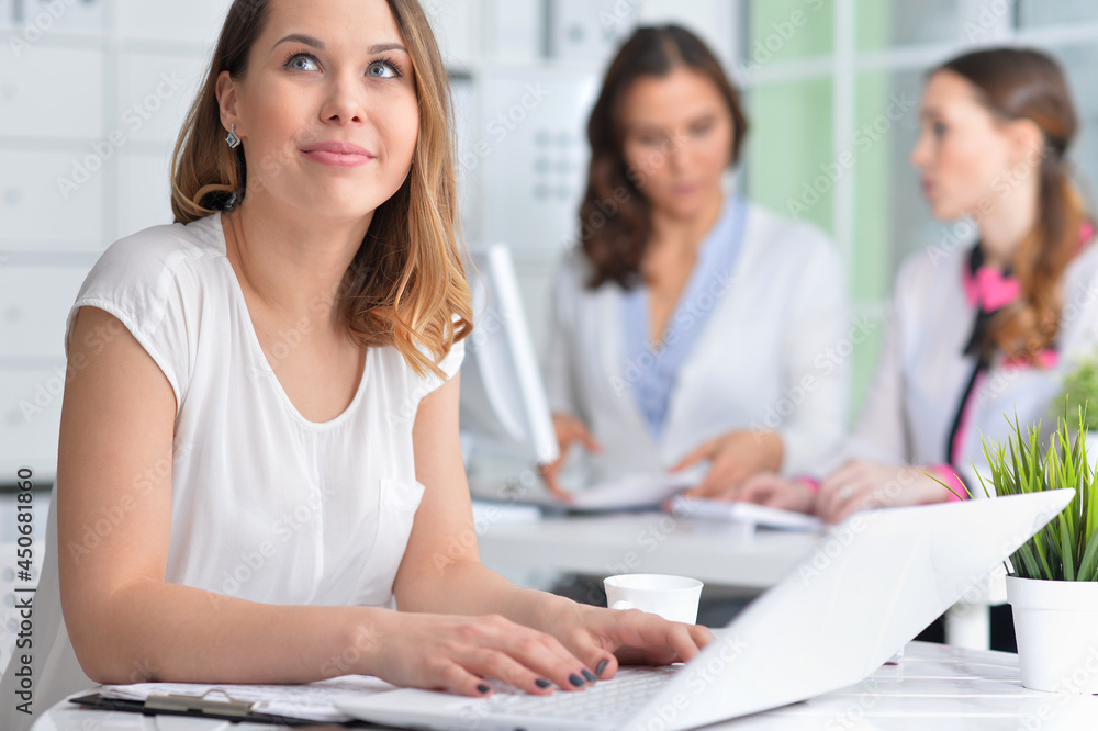 young women sit at the table and work in a modern office young women sit at the table and work in a modern office