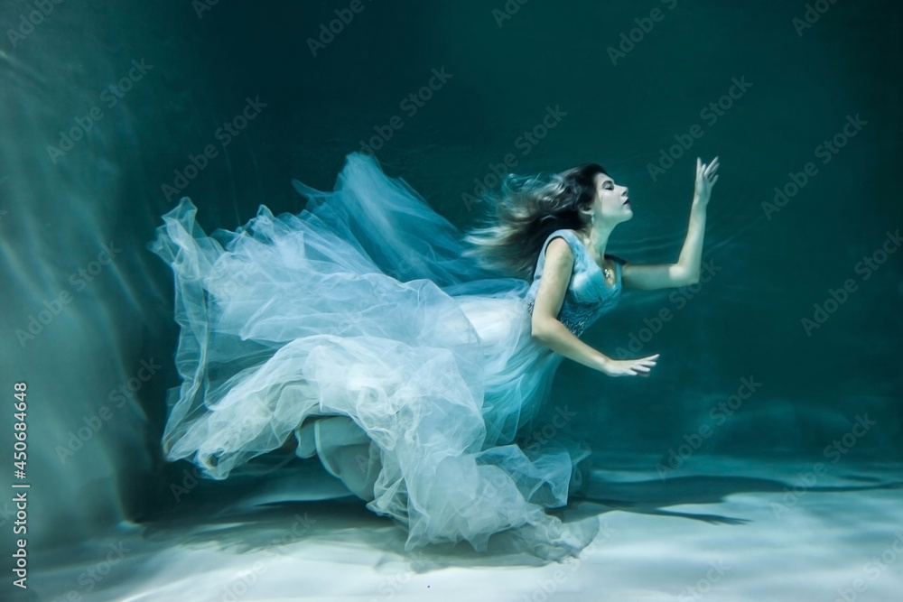 Girl under water in a chic wedding dress. like a mermaid Girl under water in a chic wedding dress. like a mermaid