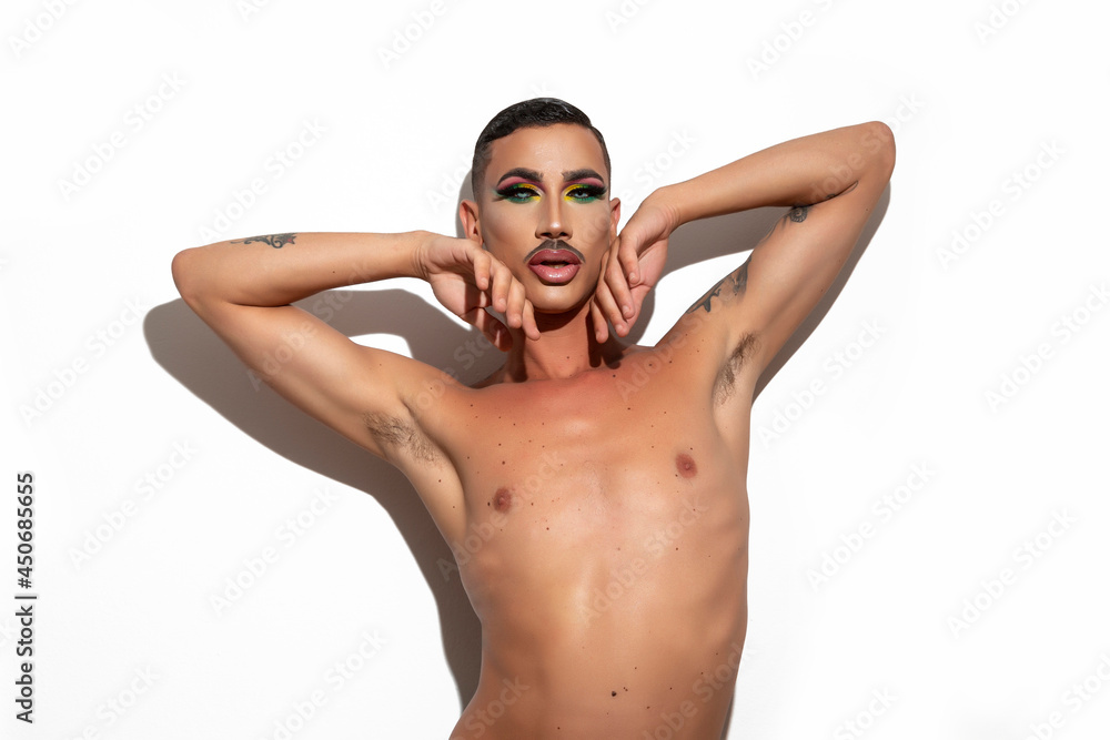 beautiful young drag queen with short hair and mustache with makeup looking at the camera with white background