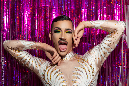 Fotografie young gay man with makeup happy smiling with a colorful background