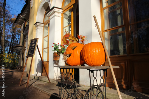 Still life with Halloween pumpkin in front of a cafe in an autumn park, close-up